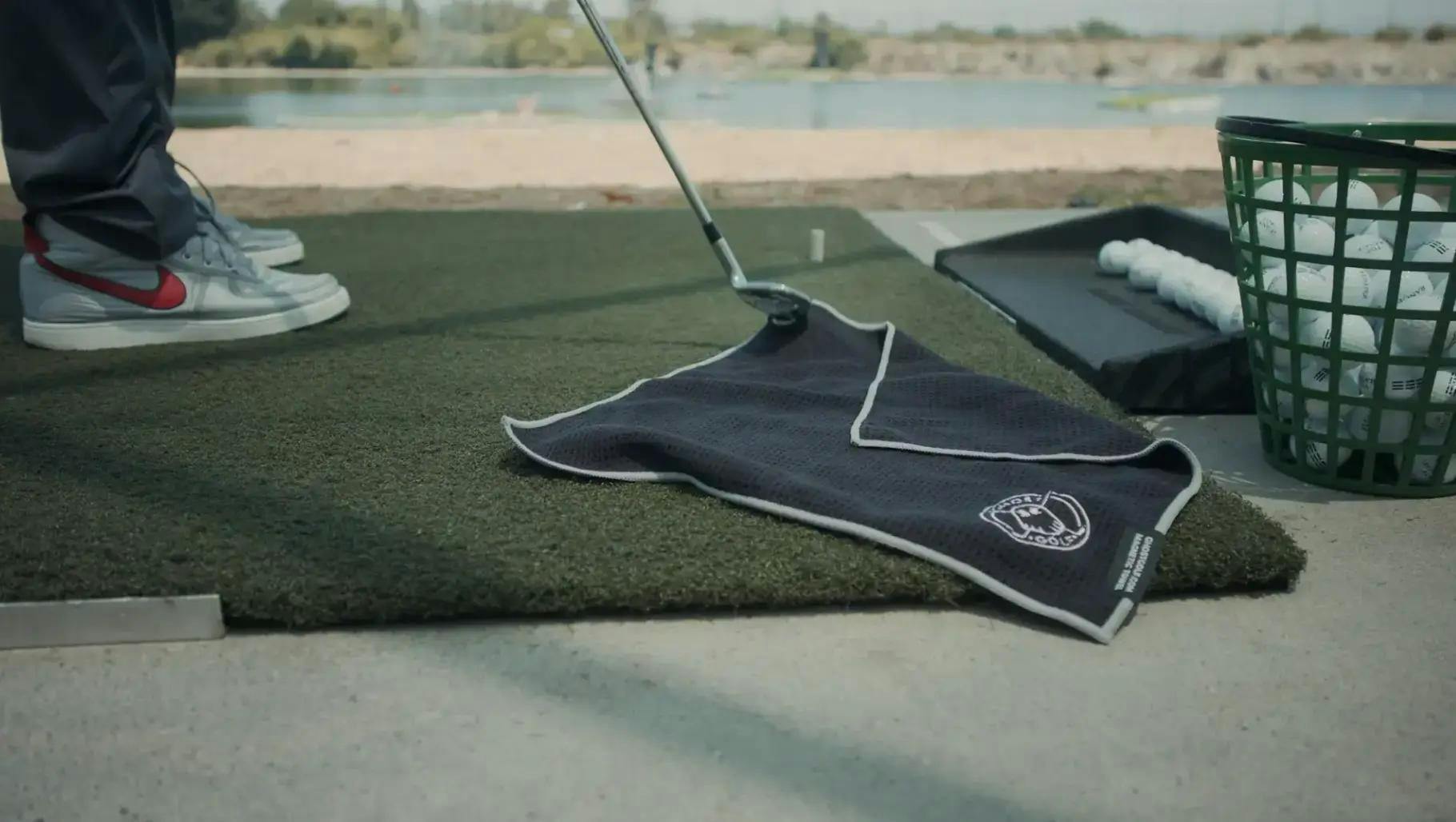 Ein Ghost Golf-Handtuch auf dem Boden einer Driving Range 